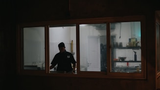 man in black shirt standing near window