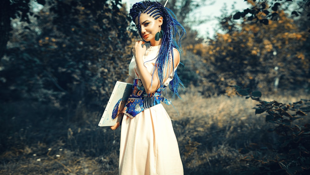 woman in white and blue dress holding book