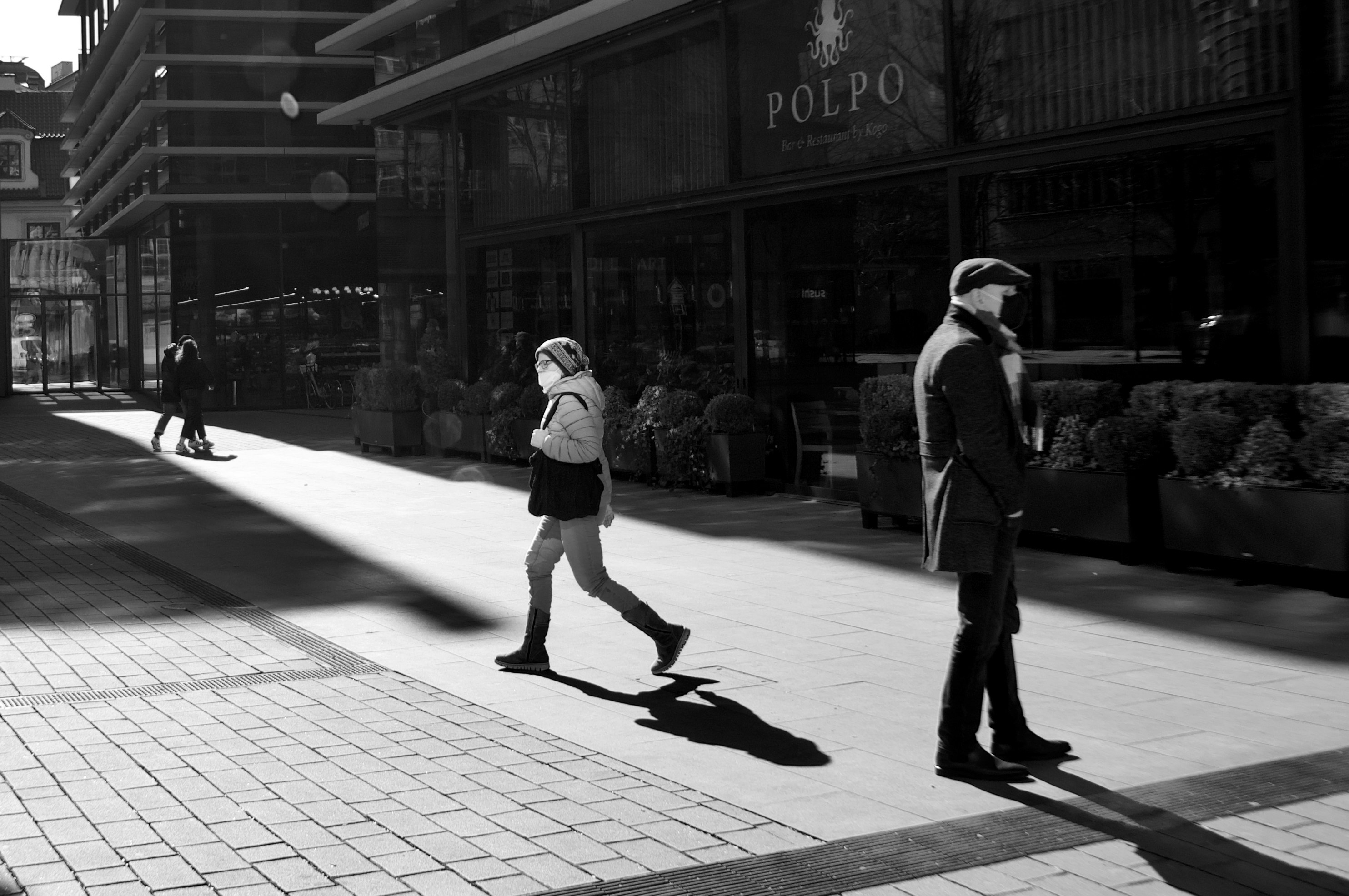 man and woman walking on sidewalk during daytime