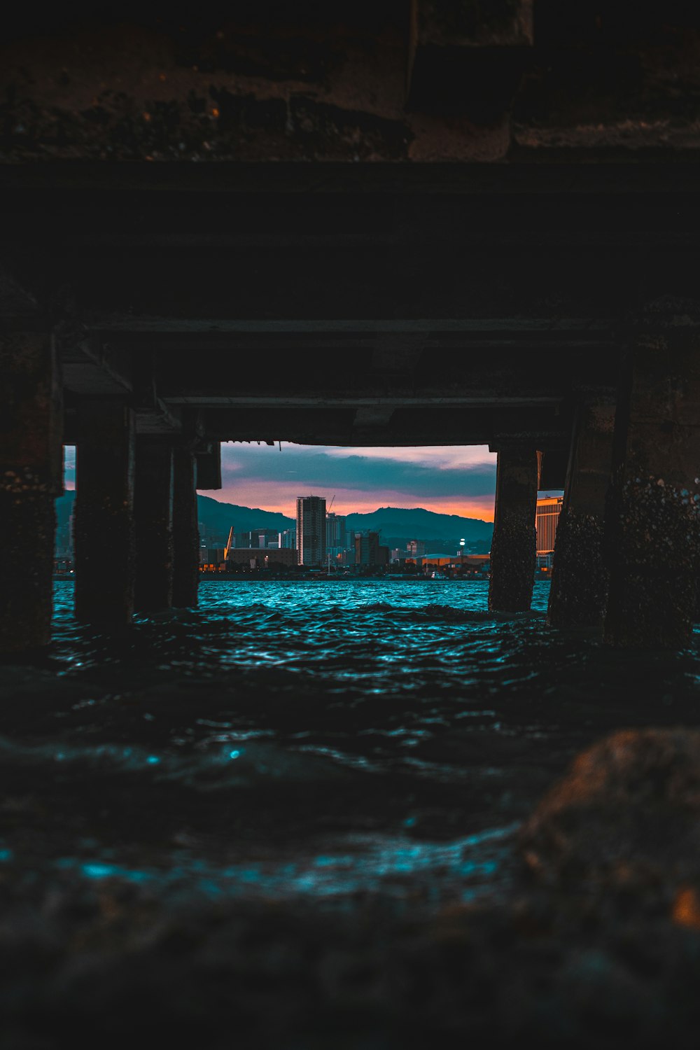 Specchio d'acqua sotto il ponte durante il tramonto