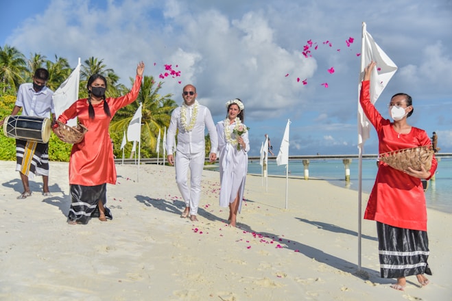 man in white thobe standing beside woman in red dress