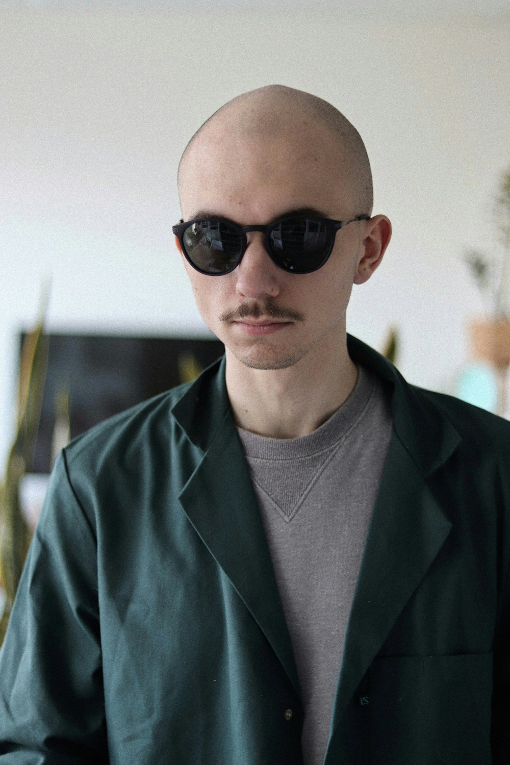 man in green button up shirt wearing black sunglasses