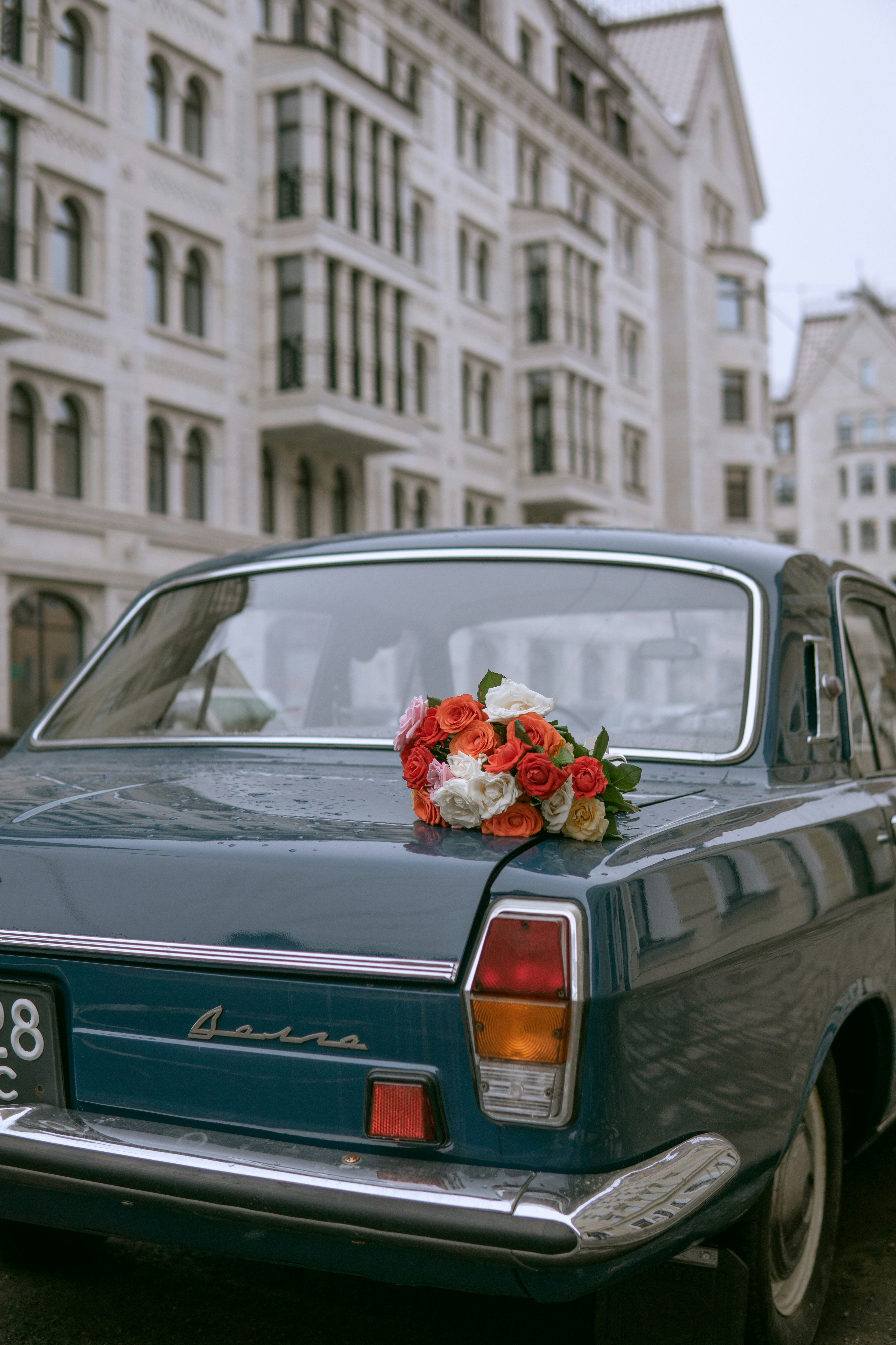 white and red flower bouquet on gray car