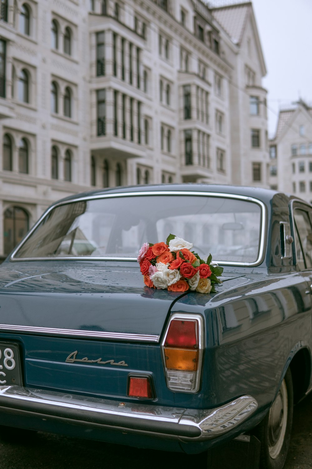 white and red flower bouquet on gray car