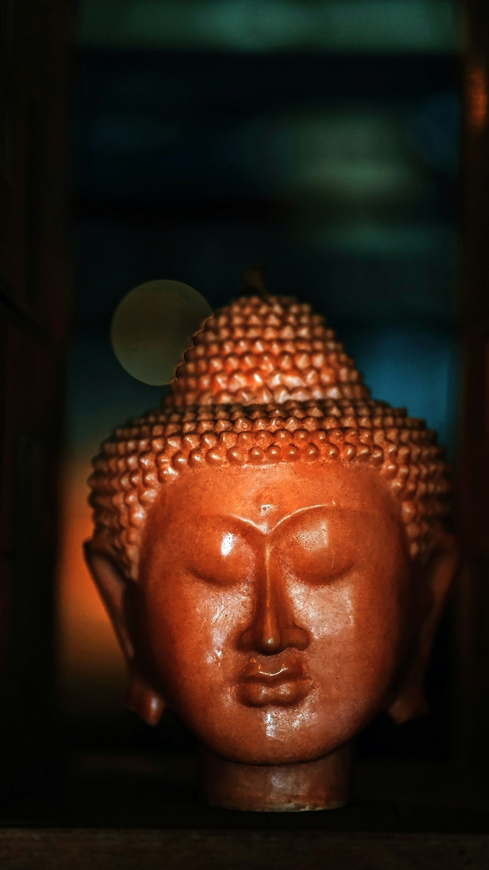 gold buddha head bust on brown wooden table