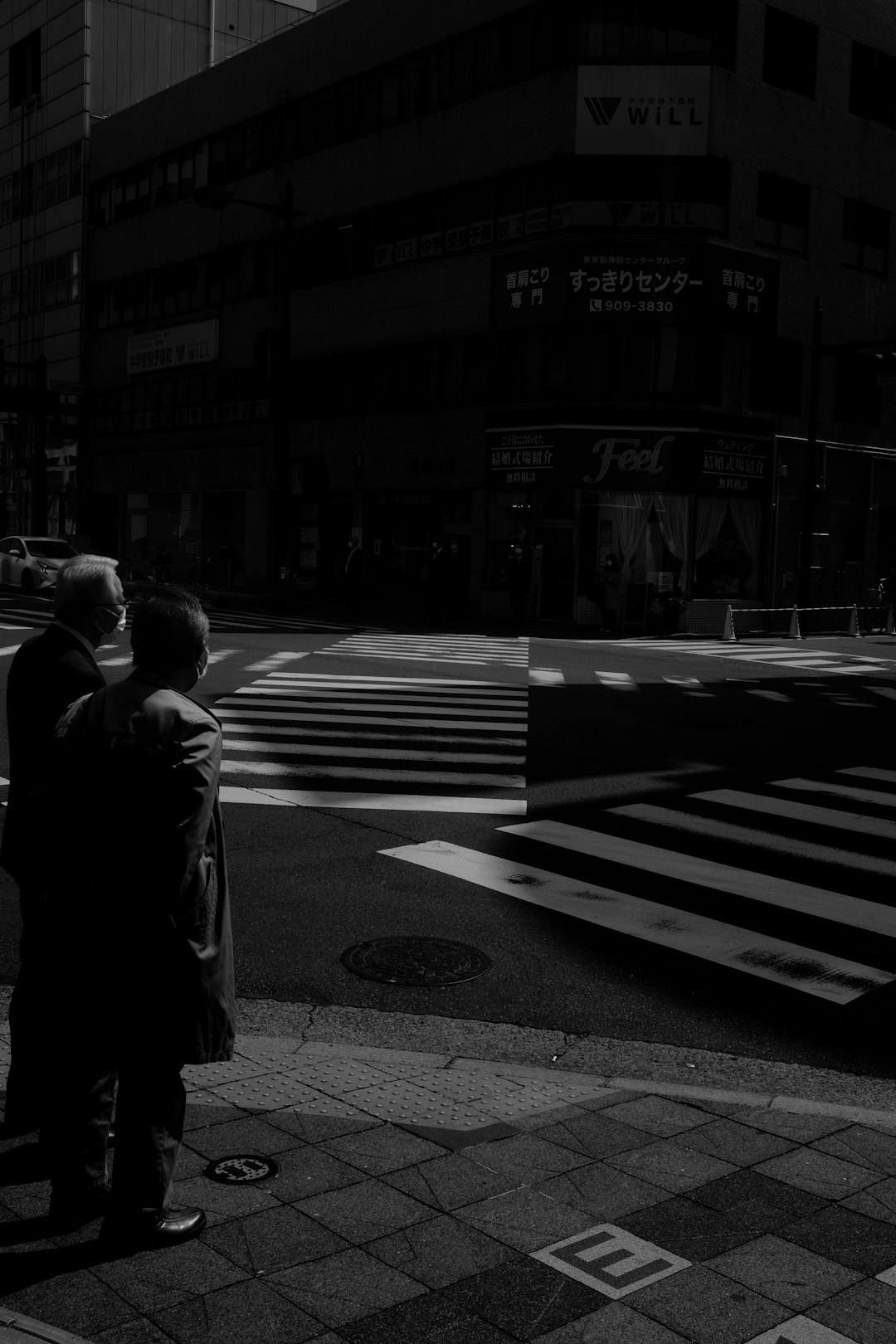 grayscale photo of man walking on pedestrian lane