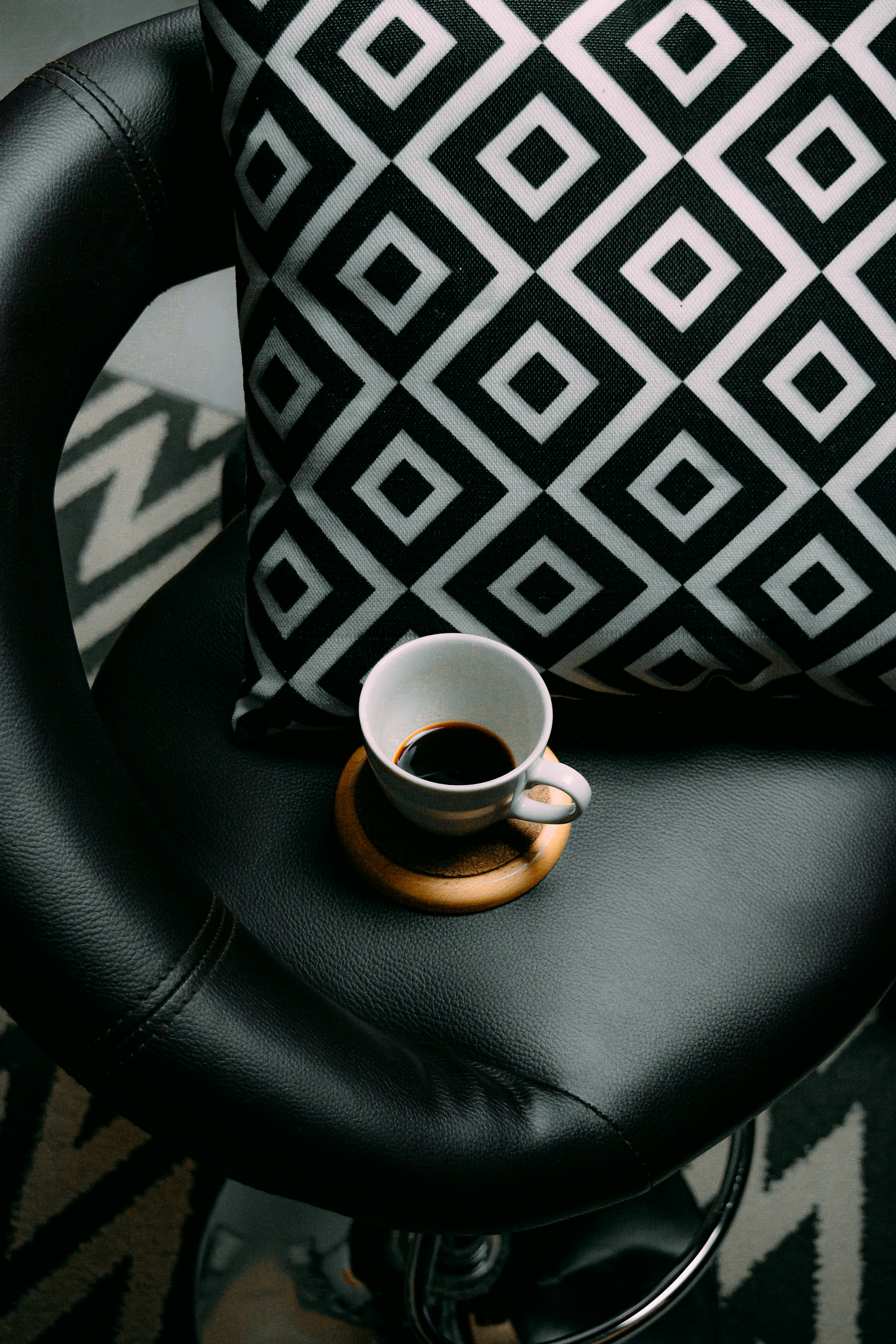 black and white ceramic mug on black leather car seat