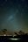 A happy couple looking up at a clear night sky filled with stars during a guided tour.