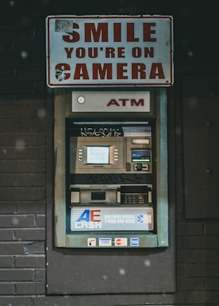 a atm machine with a sign that says smile you're on camera