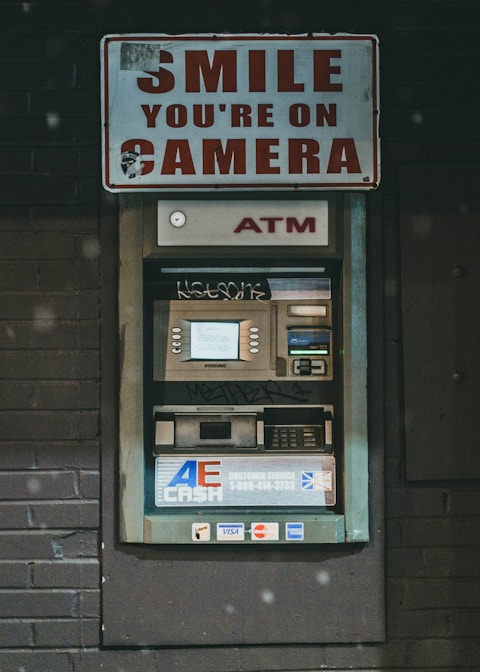 a atm machine with a sign that says smile you're on camera