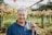 Portrait of a smiling man in his 40s standing in a vineyard during golden hour.