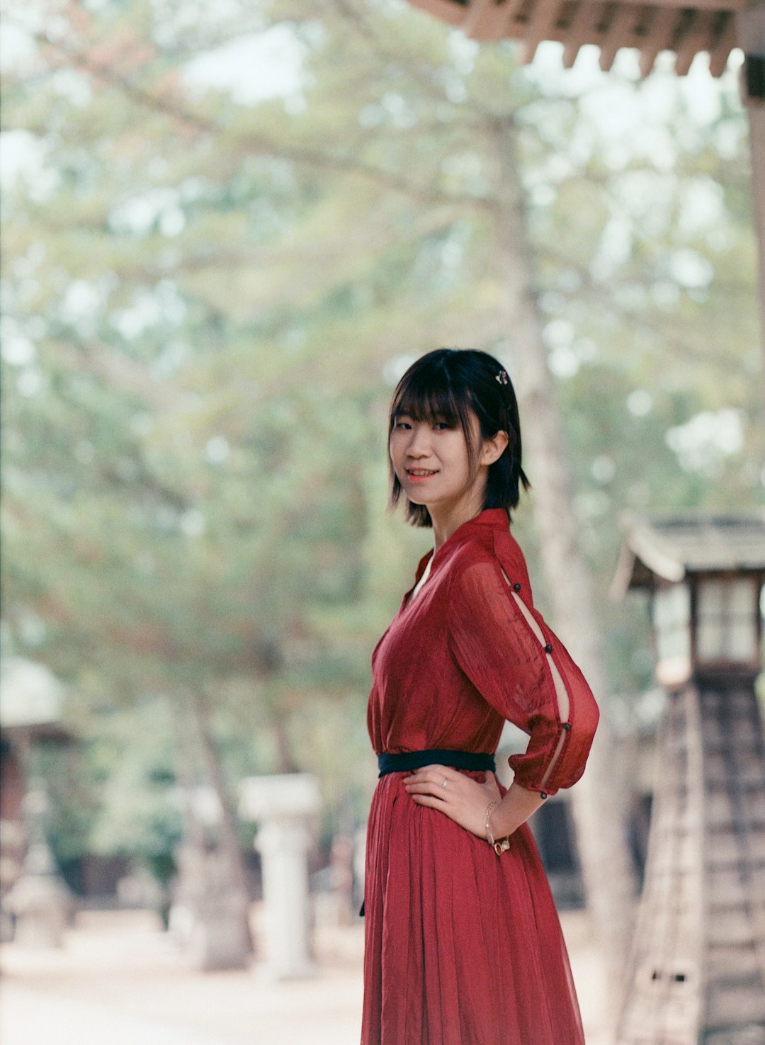 woman in red long sleeve dress standing near trees during daytime