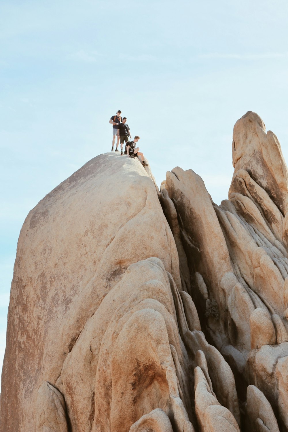 man in black jacket standing on brown rock formation during daytime