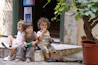 2 boys and girl sitting on concrete bench