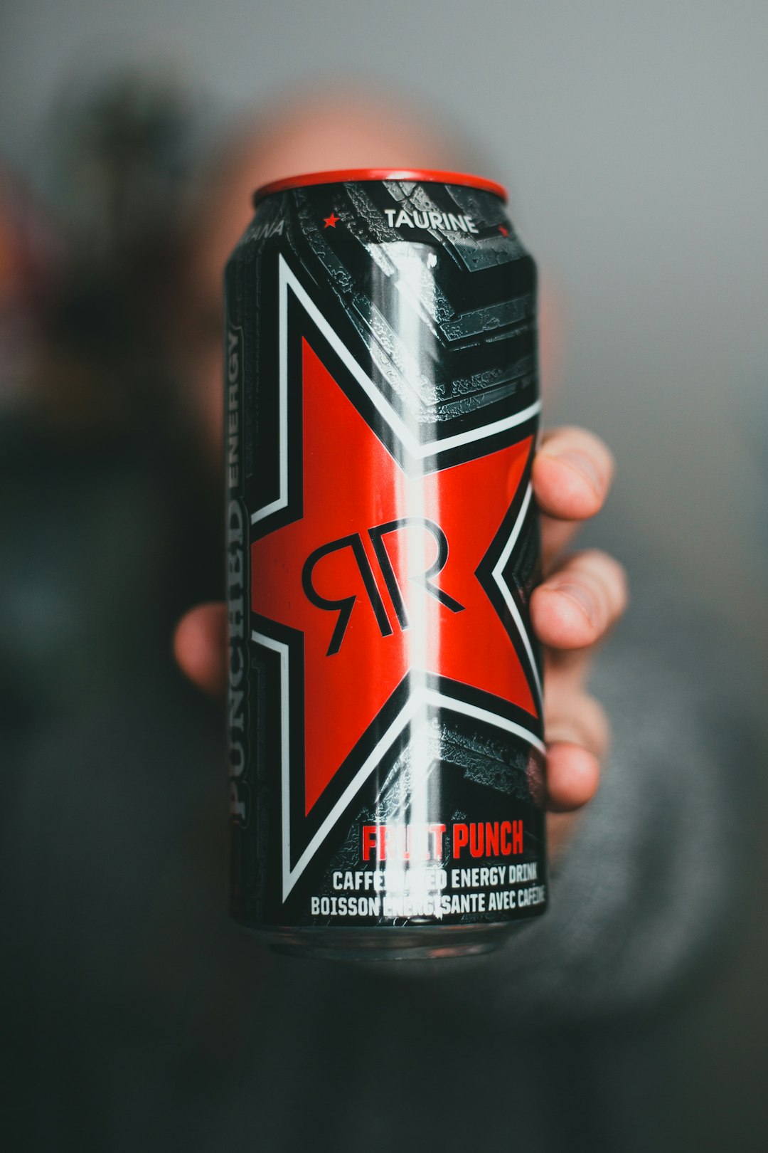 black and red can on persons hand