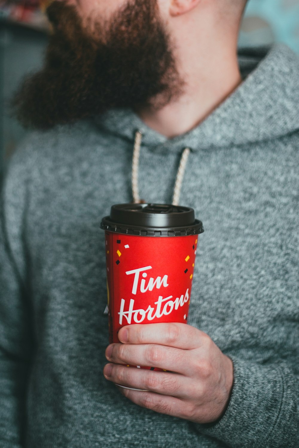 woman holding red and black disposable cup