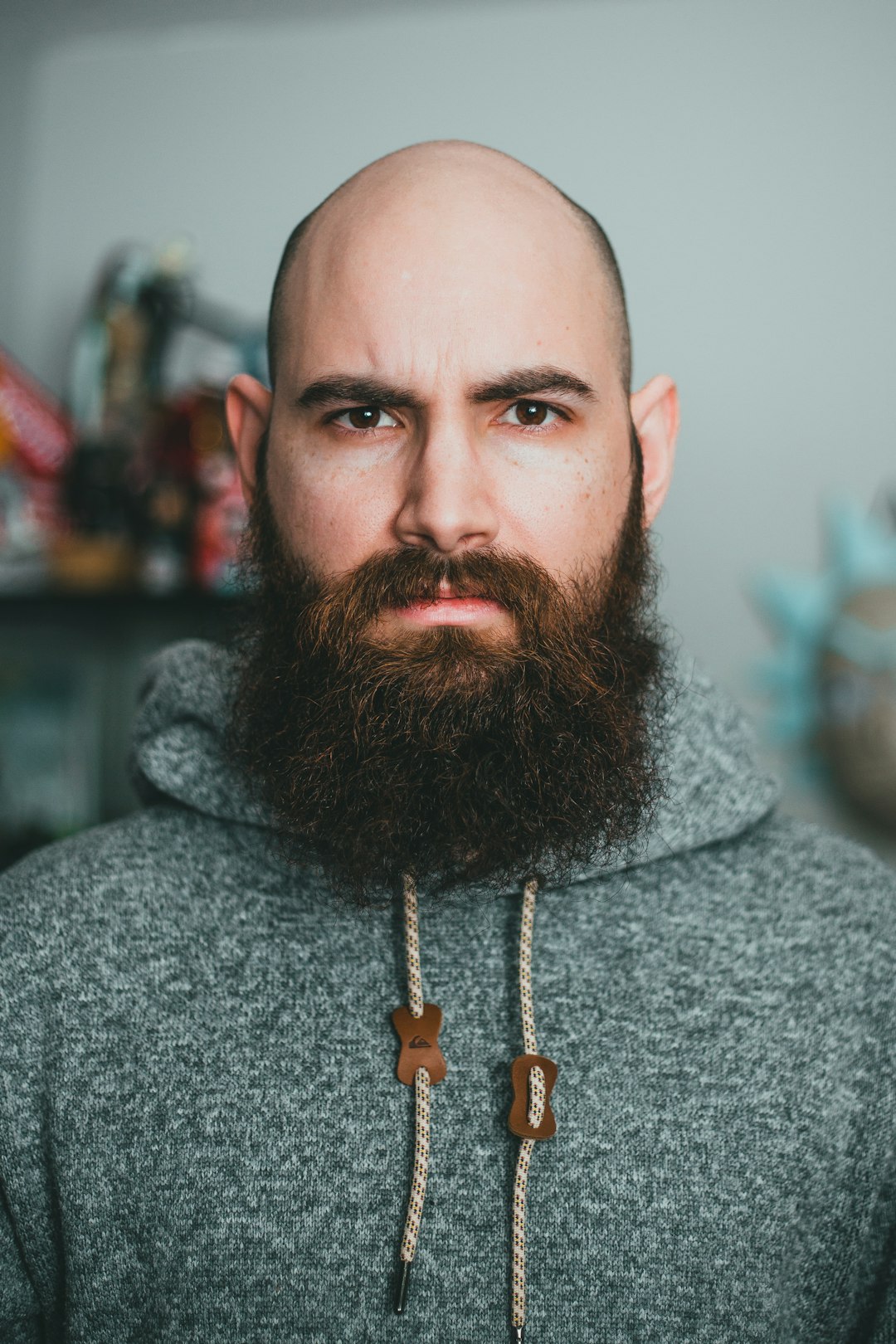 man in gray hoodie wearing gold cross pendant necklace