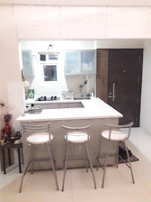 Modern kitchen area with stainless steel appliances and a breakfast bar.
