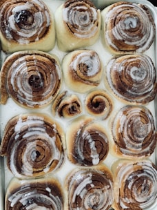 A tray of warm cinnamon rolls glazed with icing, fresh from the oven.