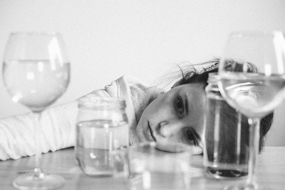 grayscale photo of woman drinking water from can