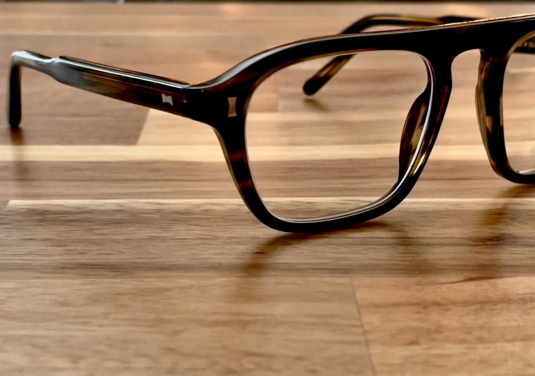 brown framed eyeglasses on brown wooden table