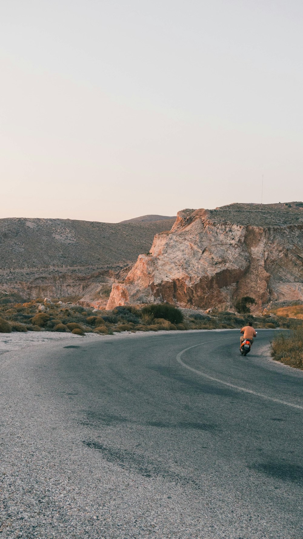 2 people sitting on gray asphalt road during daytime