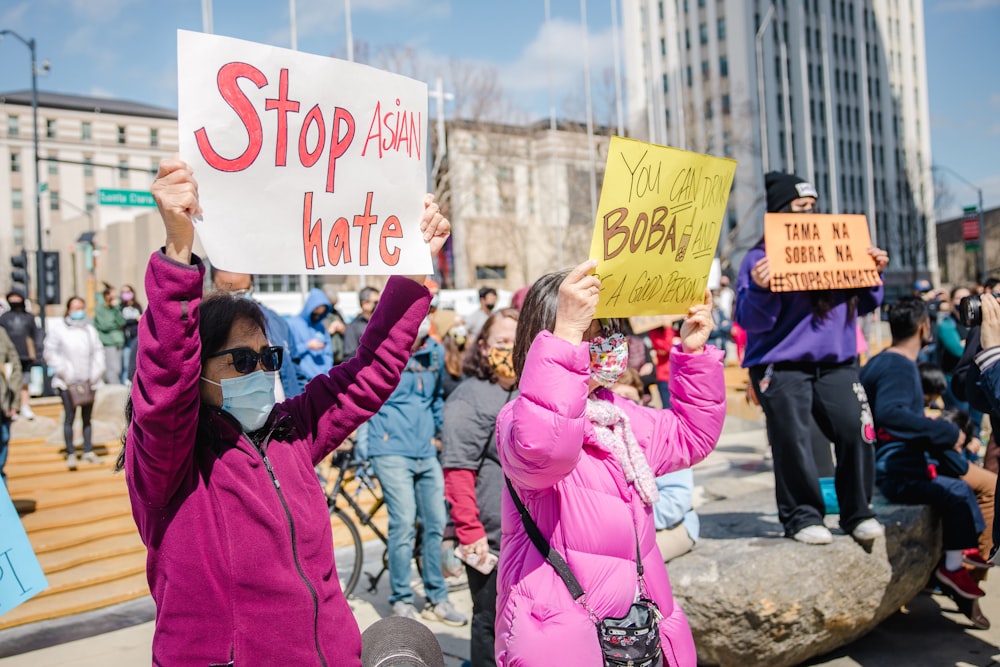 woman in pink jacket holding white and blue banner