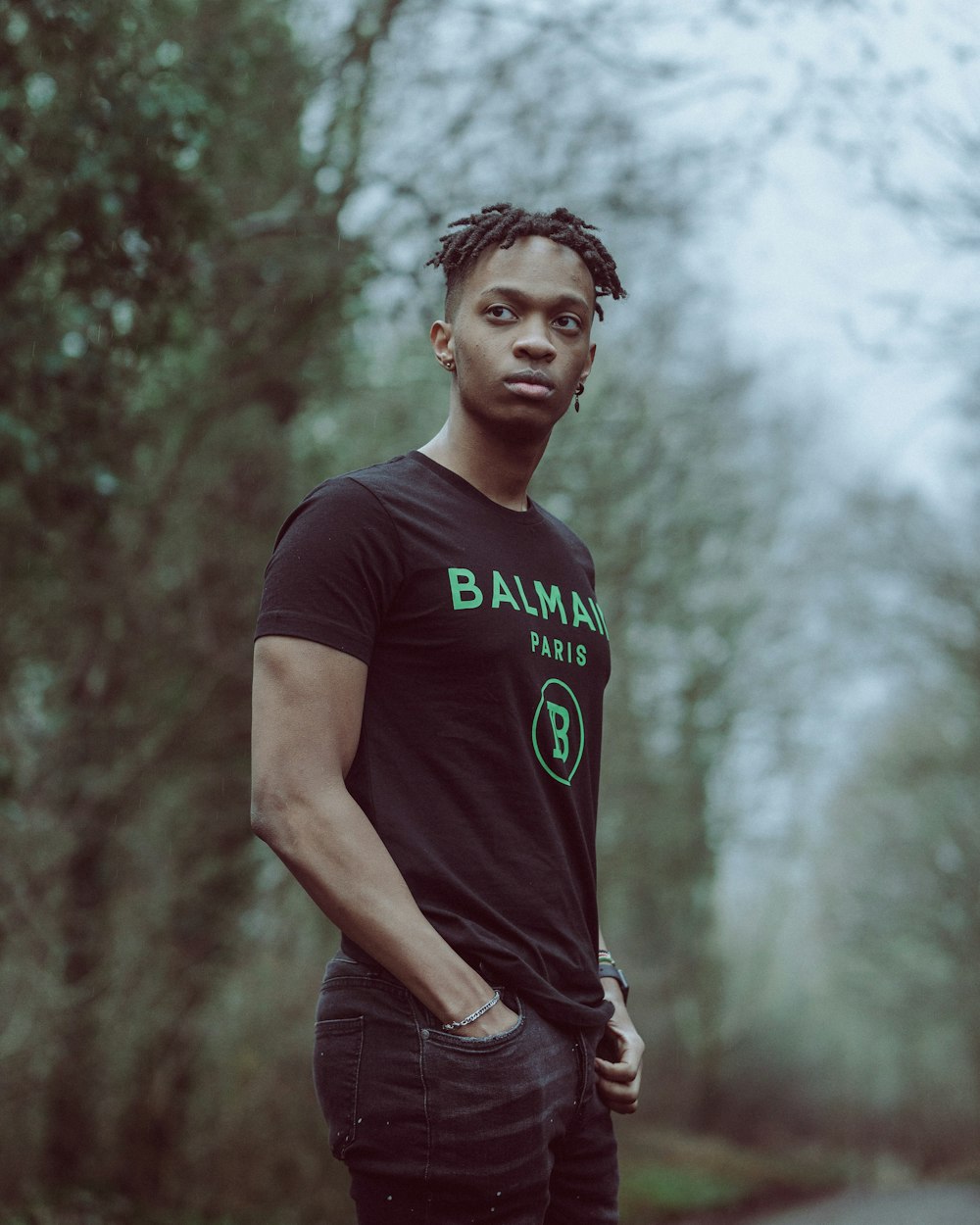 man in black crew neck t-shirt standing under white sky during daytime