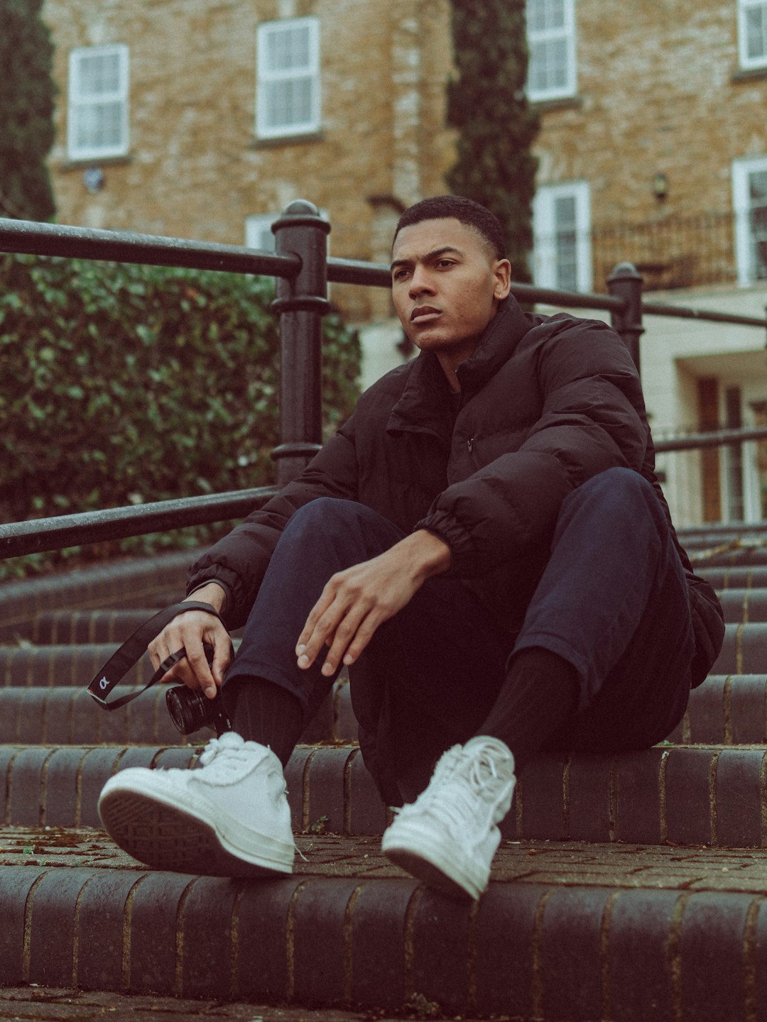 man in purple jacket sitting on brown concrete bench during daytime