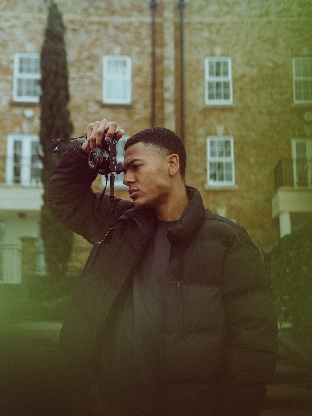 man in black jacket holding black camera