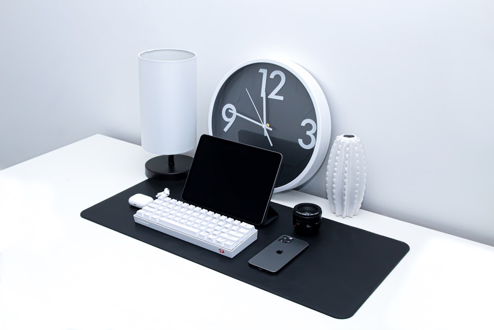 black ipad and white keyboard on black table