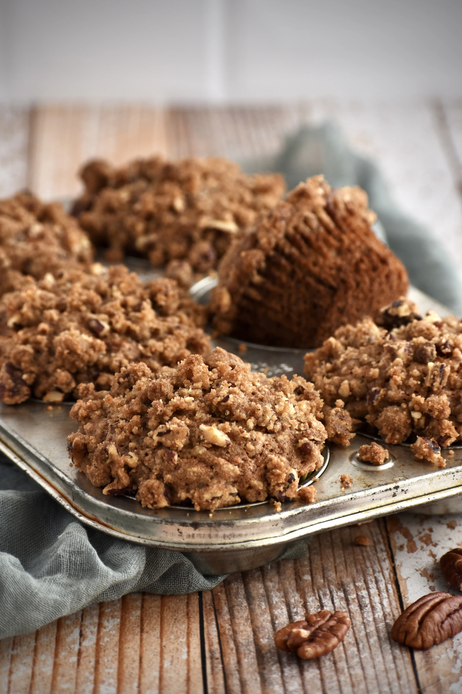 Muffins dorés recouverts d'un streusel croustillant aux éclats de noix, dans un moule