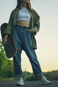 man in green jacket and blue denim jeans standing on green grass field during daytime