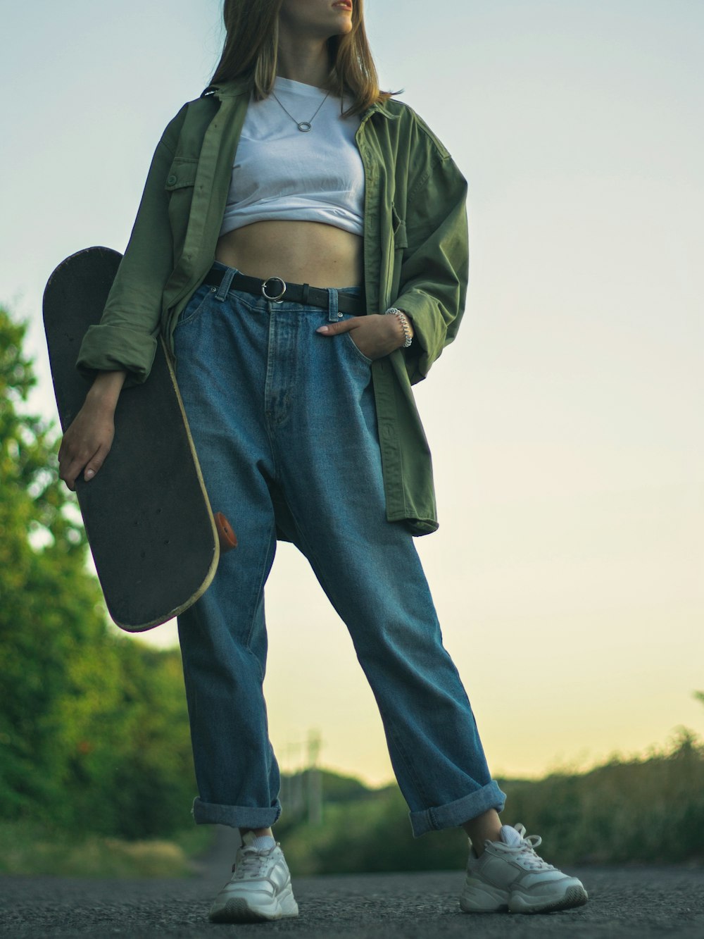 man in green jacket and blue denim jeans standing on green grass field during daytime