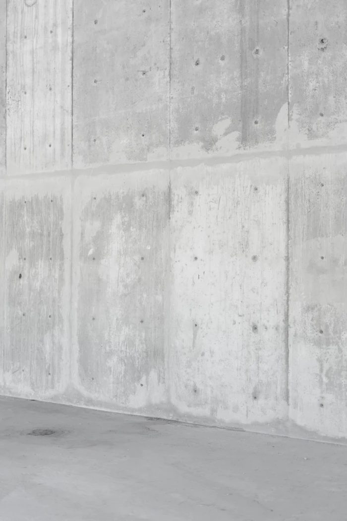 A smooth grey concrete wall lit from the side