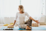 girl in white long sleeve shirt and blue pants sitting on white floor