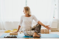 girl in white long sleeve shirt and blue pants sitting on white floor