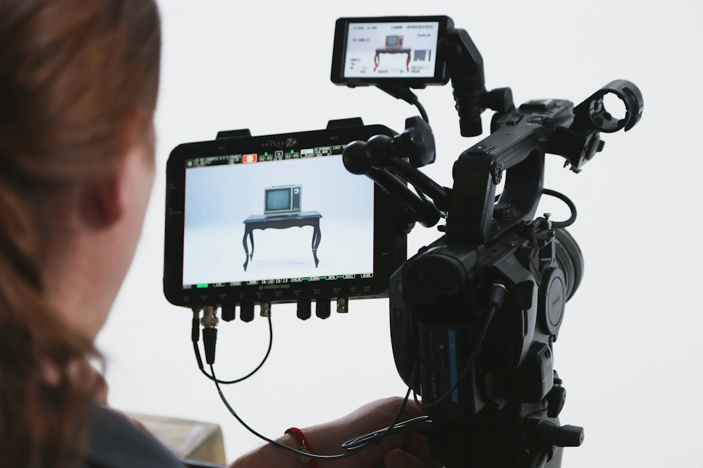 Une caméra de tournage professionnelle et son écran de contrôle, qui affiche un vieux téléviseur posé sur une table