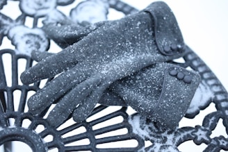 Stack of thick knit gloves with frosted edges on a snowy park bench