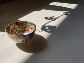 A vibrant ceramic bowl with hand-painted floral patterns glowing under soft natural light.