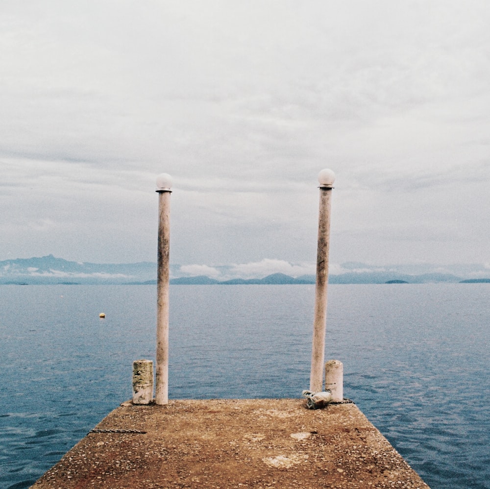 brown wooden dock on body of water during daytime