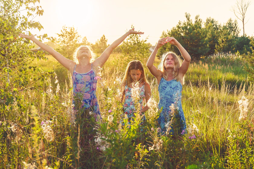 3 girls in blue and white floral dress standing on pasture during daytime