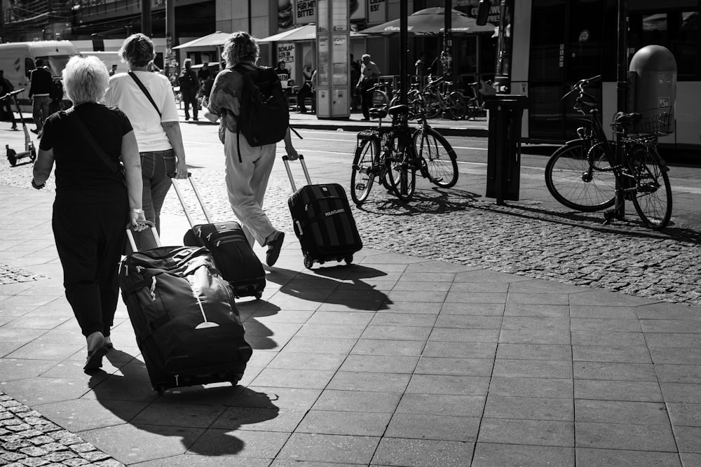 grayscale photo of man and woman walking on sidewalk