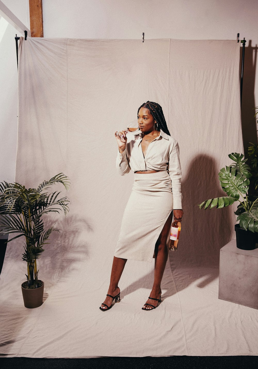 woman in white long sleeve dress standing beside green plant