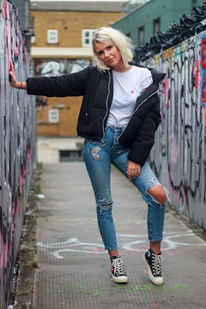 A model wearing a relaxed punkyarn sweatshirt, leaning against a graffiti-covered wall in the city.