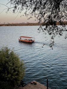 red boat on body of water during daytime