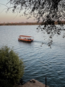 red boat on body of water during daytime