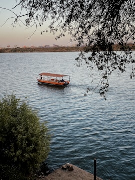 red boat on body of water during daytime