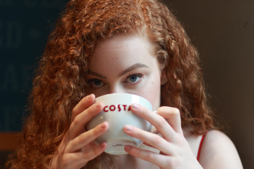 woman holding white ceramic mug