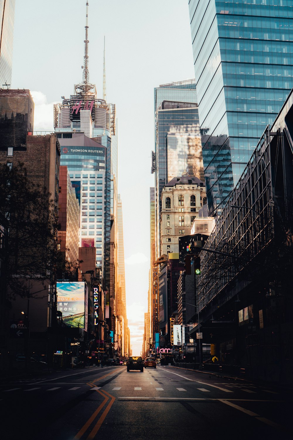 cars on road between high rise buildings during daytime